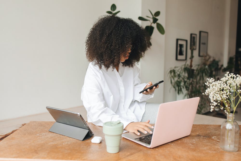 women with natural hair and a pink laptop