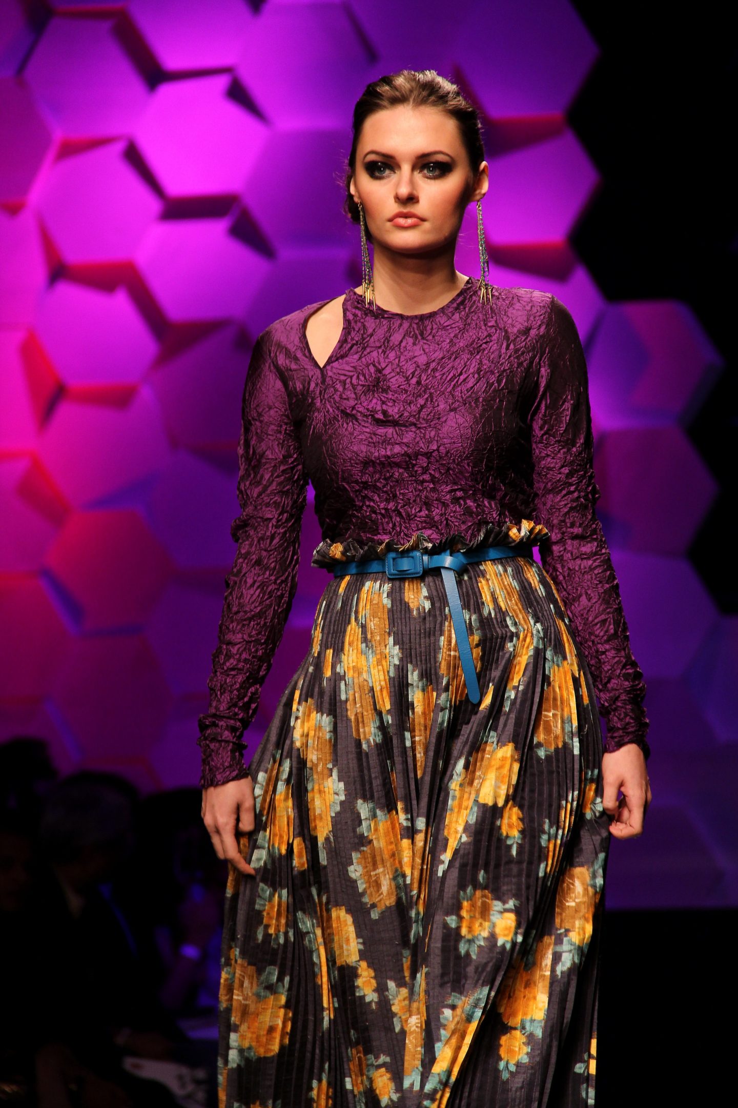 lady on runway with multi color skirt and purple cold shoulder top