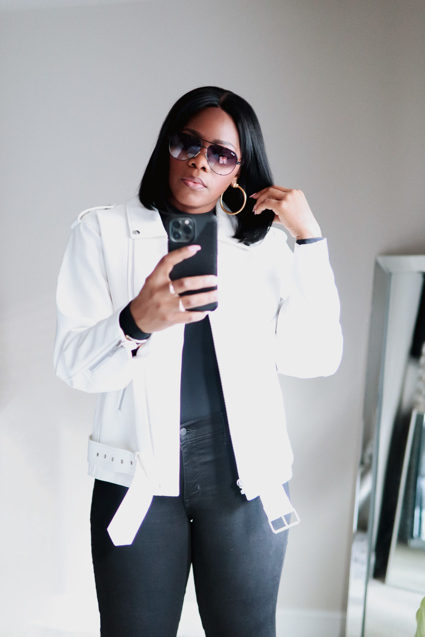 white leather moto jacket with black jeans and a black top.